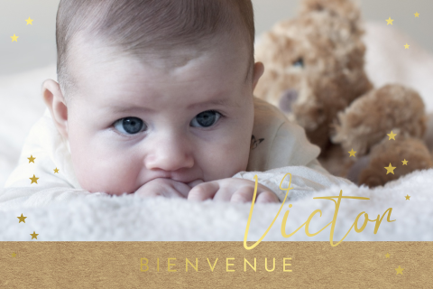 Faire-part naissance avec un une photo et des lettres en dorure.