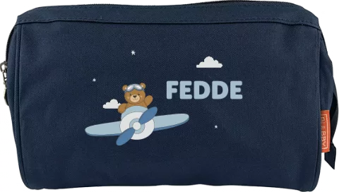 Toilettas met naam en beertje in vliegtuig