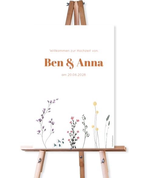 Weißes Willkommensschild zur Hochzeit mit bunter Blumenwiese