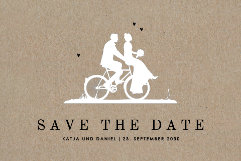 Save-the-date Kraftpapierkarte mit dem Brautpaar auf einem Fahrrad