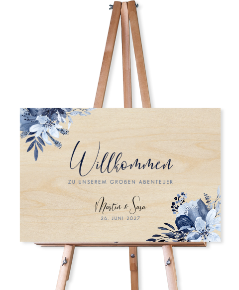 Florales Willkommensschild zur Hochzeit aus Holz mit blauem Blumenstrauß