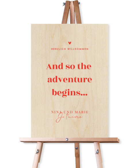 Modernes Willkommensschild aus Holz mit roter Schrift und Herz