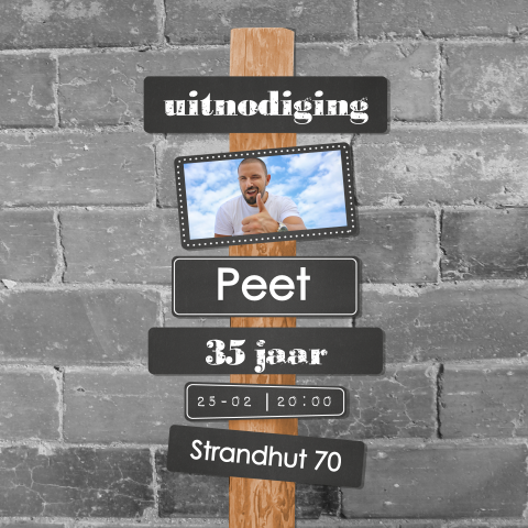 Stoere foto uitnodiging verjaardag muur met een wegwijzer